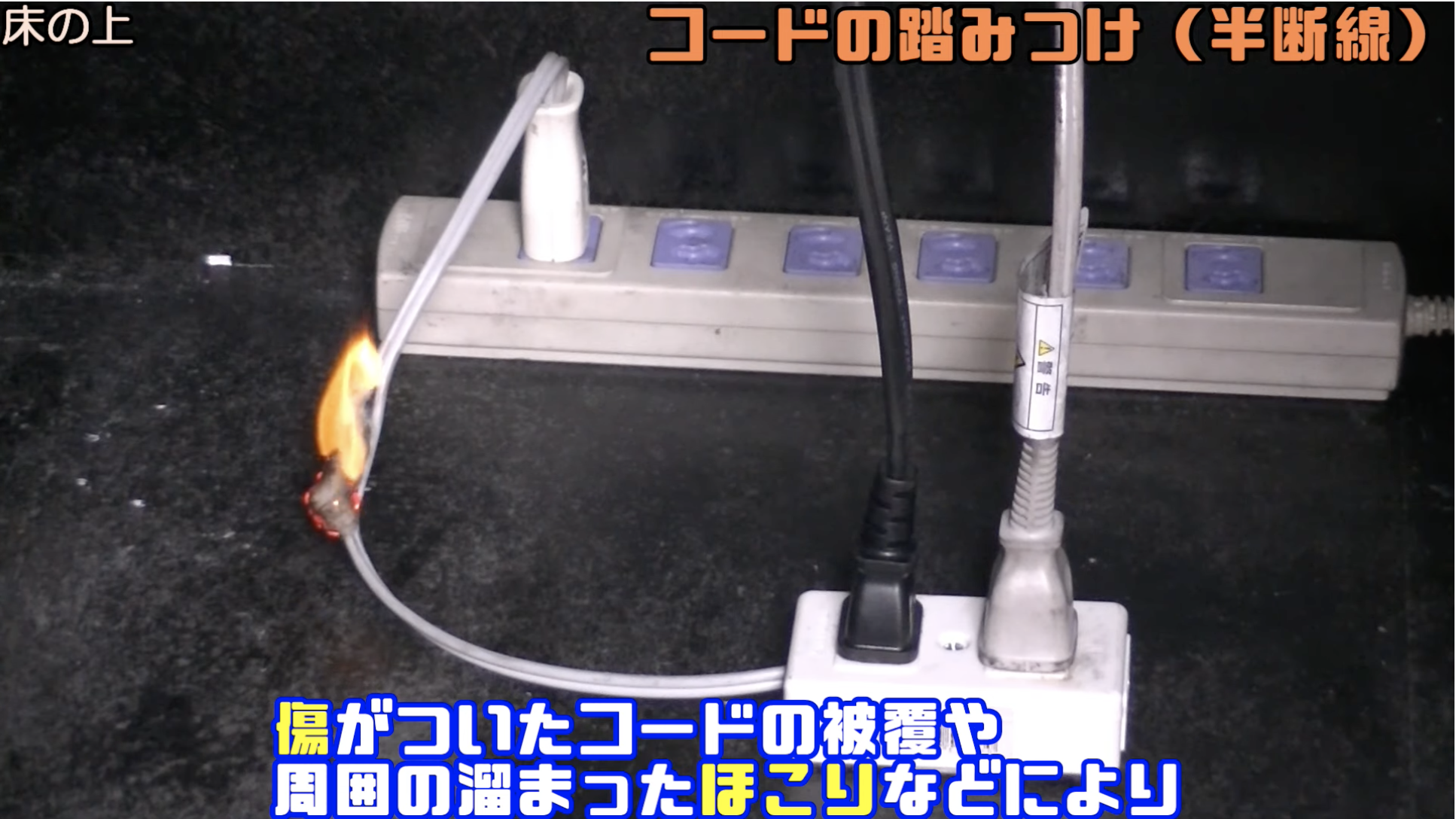 床の上　コードの踏みつけ(半断線)傷がついたコードの被膜や周囲の溜まったほこりなどにより｜出典：事業所からの電気火災を防ごう！【消防署制作動画・丸の内署】